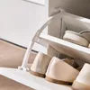 A close-up view of a white shoe cabinet with shoes stored inside. Anteprima dell’immagine prodotto