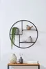A round metal wall shelf with decorative items on it, placed against a white wall. Náhled obrázku produktu