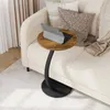 A round side table with a vintage wood-look top and a black metal base is placed next to a sofa. A tablet is on the table. Produktbild-Vorschau