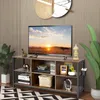 A TV stand with a TV and decorative items in a living room setting. Podgląd zdjęcia produktu