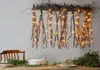 A dining table set with greenery and a decorative branch light fixture. Podgląd zdjęcia produktu