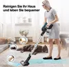 A woman is vacuuming a living room with two dogs lying on the floor. Produktbild-Vorschau