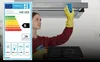 A woman cleaning a kitchen range hood. Voir les images du produit