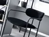A close-up view of a black bar stool in an indoor setting. Produktbild-Vorschau