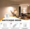 A woman is interacting with a wall switch in a modern living room, with a linear pendant light overhead. The image is overlaid with graphics and text explaining switching modes. Produktbild-Vorschau