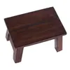 A small, dark brown wooden stool is shown against a white background. Produktbild-Vorschau