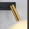 A close-up of a gold cylinder-shaped wall lamp mounted on a black base with two switches. Produktbild-Vorschau