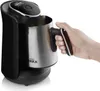 A hand holds the handle of a black and silver Turkish coffee machine. Produktbild-Vorschau