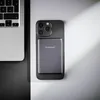 A smartphone with a power bank attached is placed next to a laptop on a split black and white surface. Produktbild-Vorschau