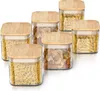 A set of six glass storage jars with bamboo lids, filled with different types of pasta and nuts, arranged on a white background. Náhled obrázku produktu