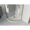 A close-up view of a modern shower cabin with a white base and gold-colored frame, featuring frosted glass panels with a striped pattern. The surrounding bathroom walls are tiled in gray and white. Podgląd zdjęcia produktu