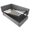 A gray upholstered corner bed frame with the mattress support slats extended upwards, revealing storage space underneath. Náhľad obrázku produktu