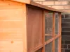 A close-up view of a wooden animal hutch with wire mesh panels. Produktbild-Vorschau