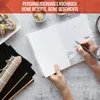 A person's hands are writing in a blank cookbook next to sushi ingredients. Produktbild-Vorschau