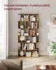 A tall, multi-tiered wooden bookshelf filled with books, decorative items, and storage boxes, placed in a room with natural light. A sofa and coffee table are partially visible in the foreground. Produktbild-Vorschau