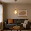 A living room scene with a sofa, coffee table, and a pendant light. Produktbild-Vorschau