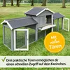 A wooden rabbit hutch with multiple doors, set up on a grassy lawn. Produktbild-Vorschau