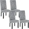 Four gray upholstered dining chairs with tufted backs are arranged in a staggered formation against a white background. Produktbild-Vorschau
