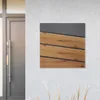 A mailbox with a wood-look front is mounted on a textured white wall next to a gray door. Náhled obrázku produktu