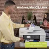 A man is using a Brother printer in an office environment with other people in the background. Voir les images du produit
