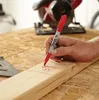 A person is marking a piece of wood with a red Sharpie marker. Voir les images du produit