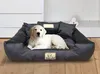 A golden retriever puppy lies on a large, dark gray dog bed with pillows. Anteprima dell’immagine prodotto