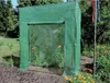 A green greenhouse with tomato plants inside, set in a garden. Náhled obrázku produktu