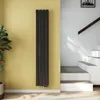 A vertical radiator is mounted on a yellow wall next to a staircase. Voir les images du produit