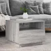 A modern living room setting with a grey couch and a grey side table. Produktbild-Vorschau