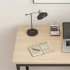 A desk with a lamp, open book, calendar, and laptop. Produktbild-Vorschau