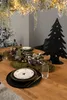 A Christmas-themed table setting with a black metal tree decoration and a mossy centerpiece. Produktbild-Vorschau