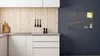 A modern kitchen with white cabinets and a wooden backsplash, featuring a black marble magnetic board on the dark gray wall. Anteprima dell’immagine prodotto