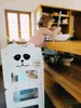 A young child is using a white learning tower in a kitchen, reaching for a bowl on the counter. Anteprima dell’immagine prodotto