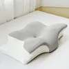 A white orthopedic pillow with a gray top surface is placed on a white bed. Produktbild-Vorschau