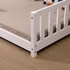 Close-up view of the side rail and mattress of a white wooden children's bed. Náhľad obrázku produktu