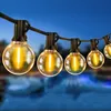 String lights with round bulbs hanging over a body of water at dusk. Náhled obrázku produktu