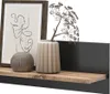 A shelf with decorative items including a framed picture, a vase with dried flowers, and a round decorative object. Produktbild-Vorschau