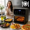 A woman smiling in a kitchen next to an air fryer and various cooked foods. Produktbild-Vorschau