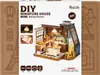 The image shows the packaging of a DIY miniature house kit, specifically a baking kitchen model. The packaging features a detailed image of the assembled miniature house, along with product information and branding. Náhľad obrázku produktu