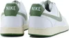 Rear view of two white Nike Court Vision Low sneakers with green accents. Produktbild-Vorschau