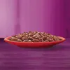 A red bowl filled with cat food sits on a purple surface. Voir les images du produit
