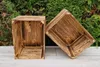 Two wooden crates are placed on a wooden surface in front of a green hedge. Produktbild-Vorschau