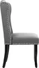 A side view of a gray upholstered dining chair with silver nailhead trim and black wooden legs, set against a white background. Produktbild-Vorschau