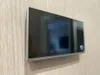 A digital peephole is mounted on a wooden door. Produktbild-Vorschau