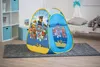 A Paw Patrol pop-up tent is set up on a rug in a child's room, next to a bed and a shelf unit. Produktbild-Vorschau