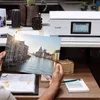 A person is holding a printed photo in front of a Canon printer. Podgląd zdjęcia produktu