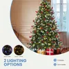 A decorated artificial Christmas tree with lights and ornaments, set in a room with gifts at its base. Produktbild-Vorschau