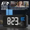 A digital alarm clock with a woman in the background demonstrating a feature. Náhľad obrázku produktu