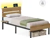 A single bed with a headboard featuring LED lighting and USB ports, shown with bedding and storage boxes underneath. Produktbild-Vorschau