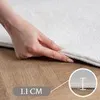 A hand is shown lifting the edge of a white rug to demonstrate its thickness. Produktbild-Vorschau